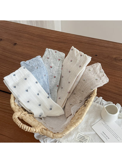 Multiple pairs of Rufia tiny floral ribbed crew socks in assorted colors stacked