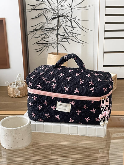 Cosbai travel makeup bag placed next to travel essentials on a wooden surface