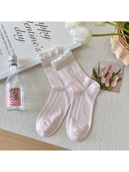 Rufia socks paired with a feminine outfit featuring a skirt and sneakers