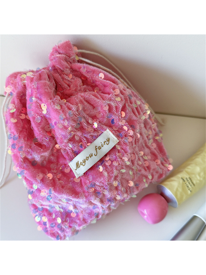 Close-up of the Pink pouch's iridescent round sequins and rectangular script label