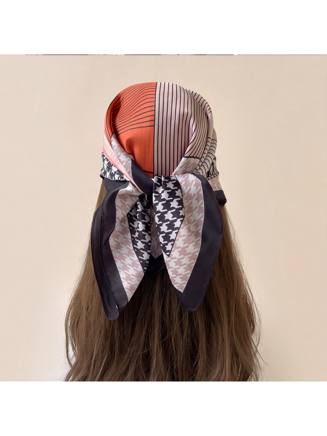 Orange patterned scarf tied over the back of the head, showing its knot and hanging tails