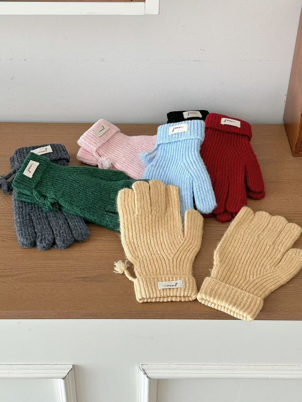 Burgundy and Green ribbed gloves displayed over Yellow and Blue gloves