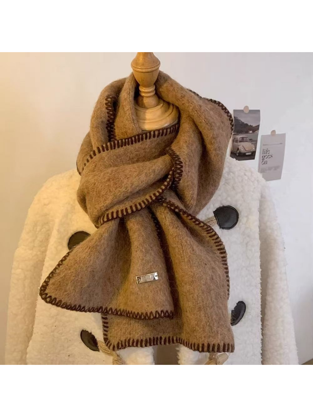 Camel scarf looped around a mannequin with both stitched ends visible