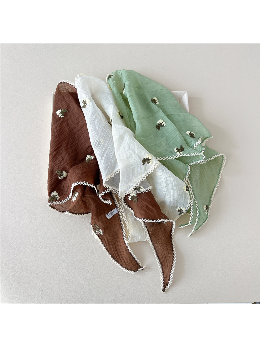 Brown, Cream and Mint floral scarves draped together, showing white edge trim
