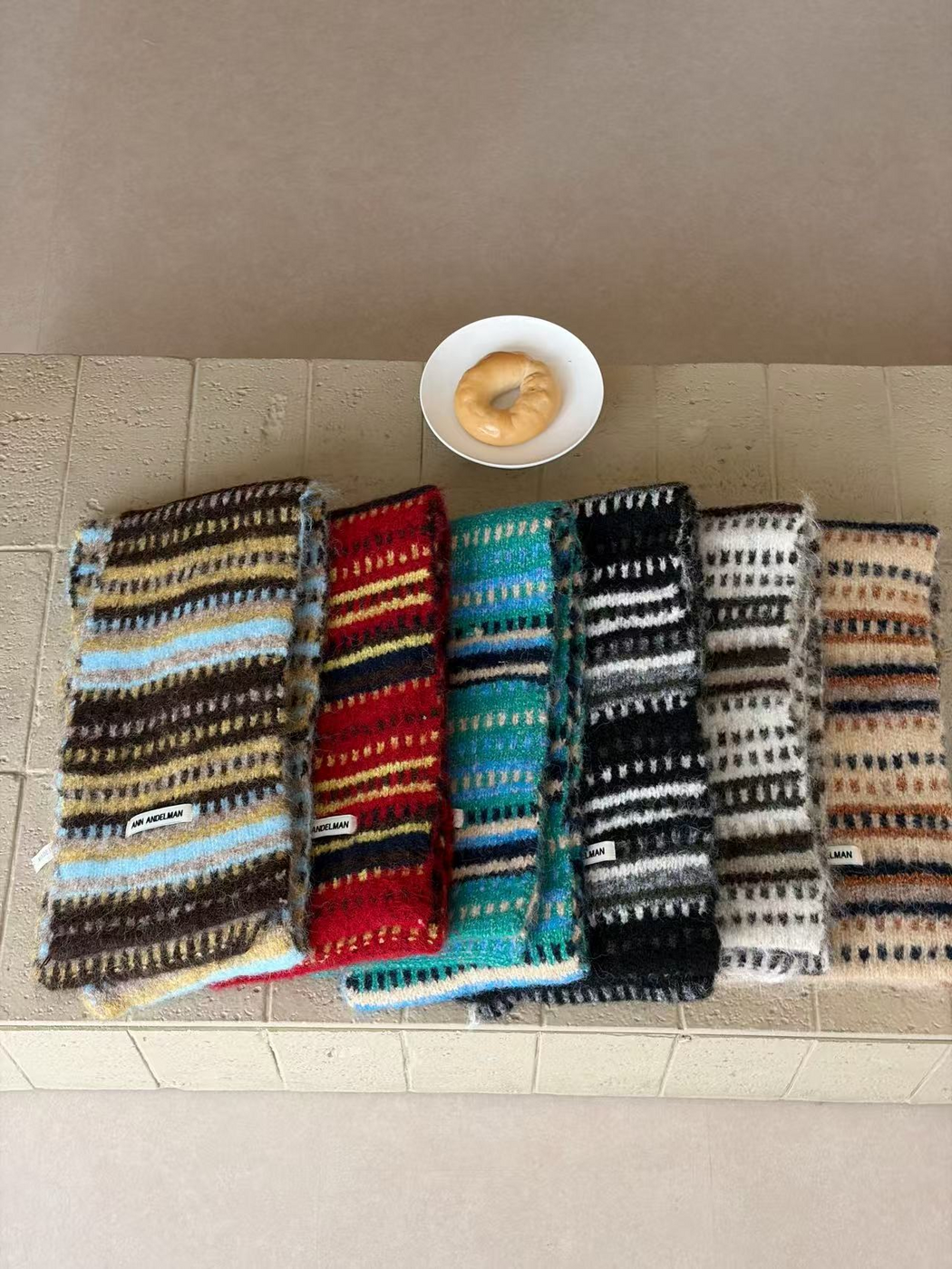 Six striped scarf colorways arranged lengthwise with overlapping edges