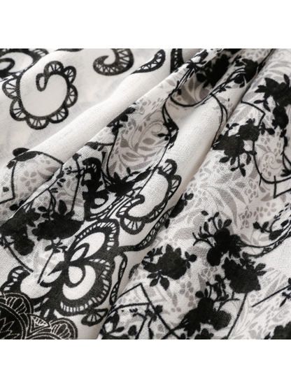Close-up of floral motifs and curling outlines across diagonal scarf folds
