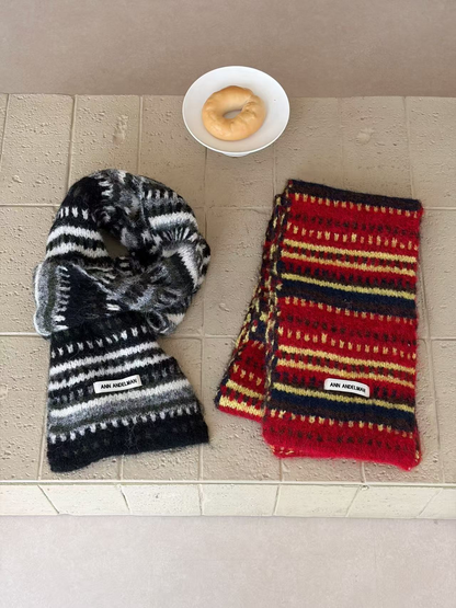 Black striped scarf loosely looped beside a lengthwise-folded Burgundy scarf
