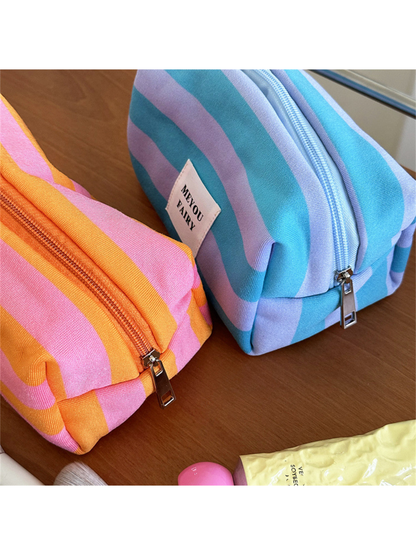Close-up of Orange and Turquoise striped makeup bags showing side seams and silver-colored pulls