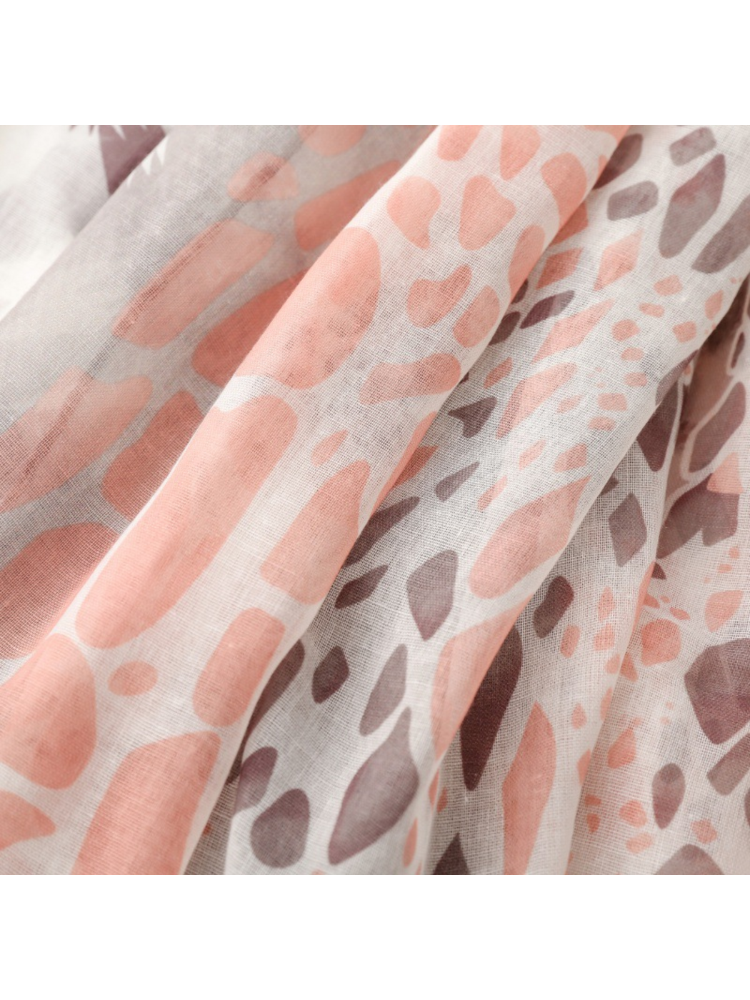 Close-up of pink and brown irregular spots across folds of the scarf