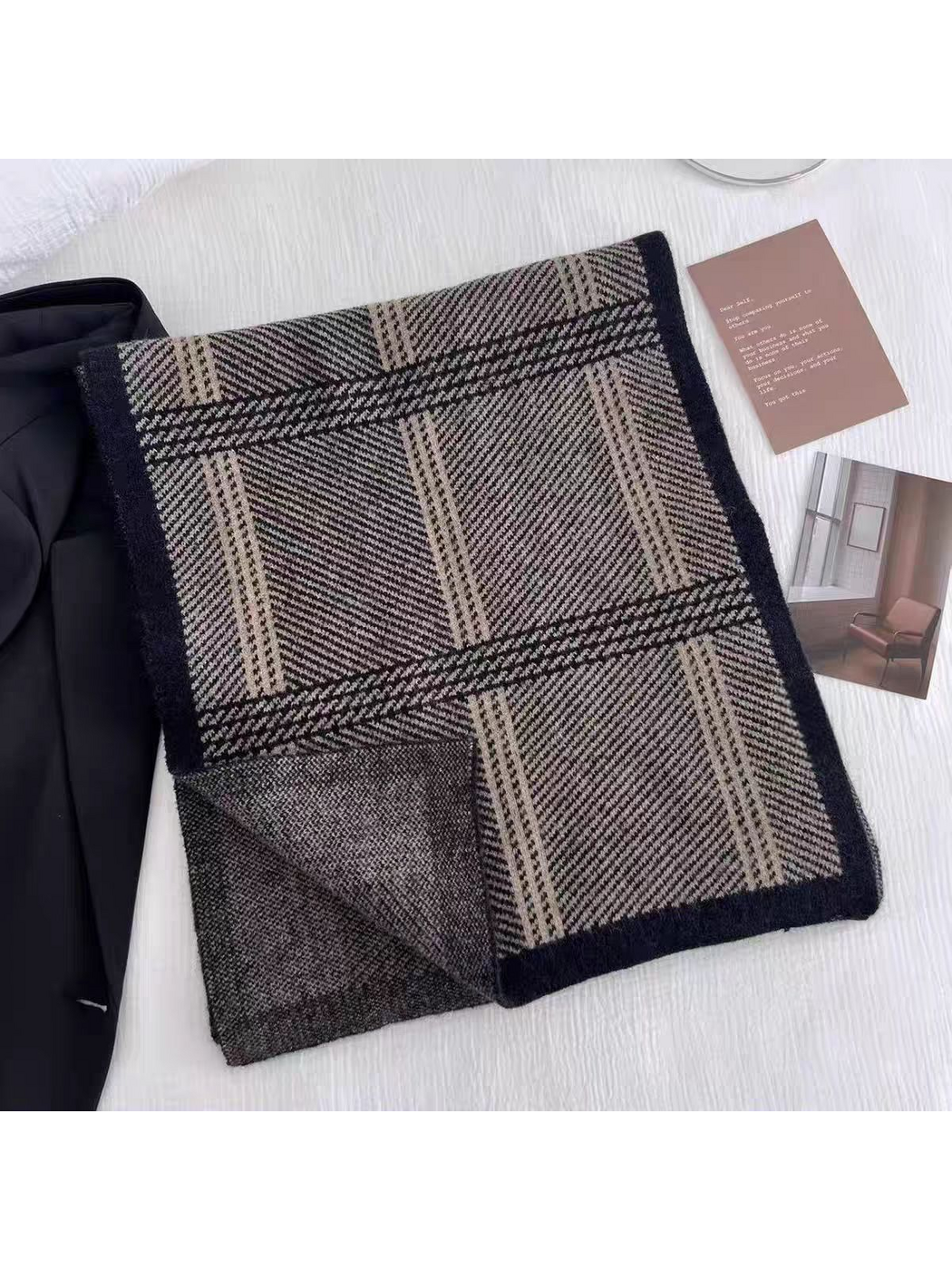 Black plaid scarf folded with one corner turned back to show the reverse surface