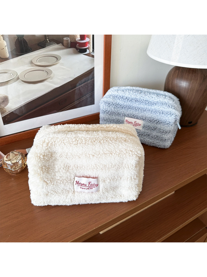 Ivory and Light Blue cosmetic pouches shown at an angle with textured fronts and tops