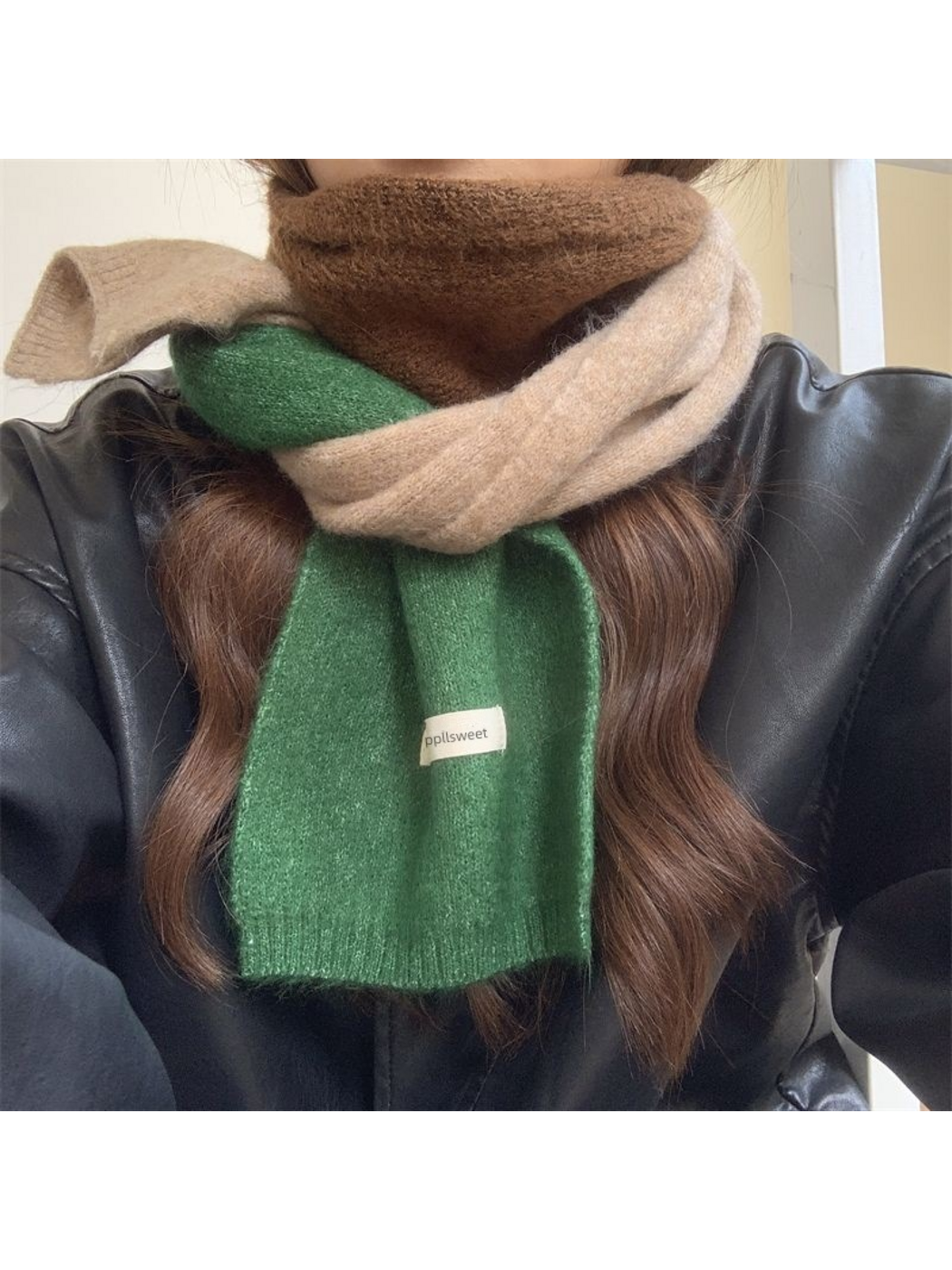 Green color-block scarf wrapped around the neck over a black jacket