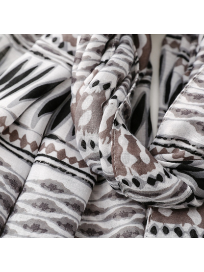 Close-up of the scarf edge and folds across gray, black and taupe pattern bands