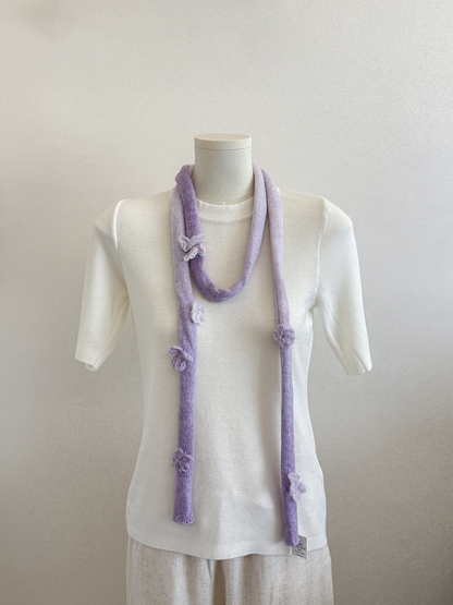 Purple gradient knit scarf with raised flower and butterfly embellishments draped on a mannequin