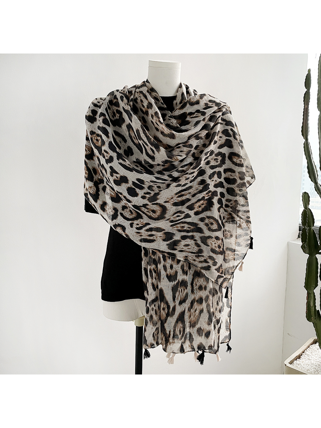 Multicolor leopard-print scarf with tassels wrapped around a mannequin