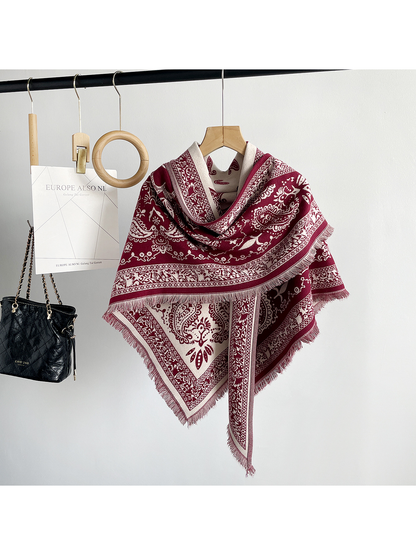 Red paisley scarf wrapped across a mannequin's shoulders with a broad fringed border