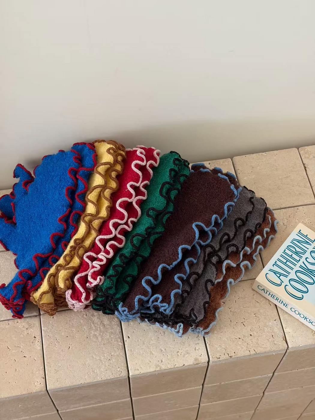 Layered mittens in seven colors showing contrasting ruffled edges and fuzzy texture