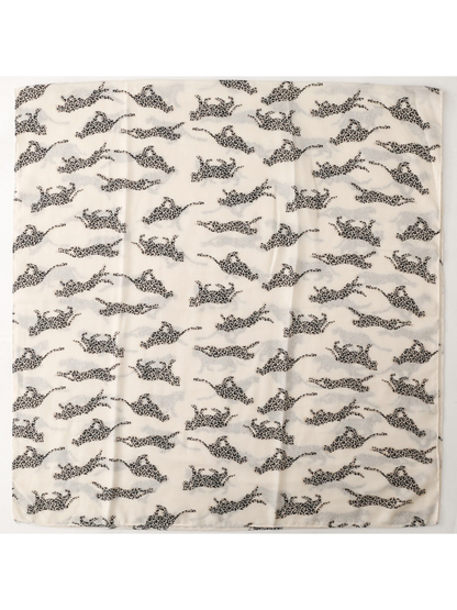 Pale scarf laid flat with repeating spotted leopard silhouettes