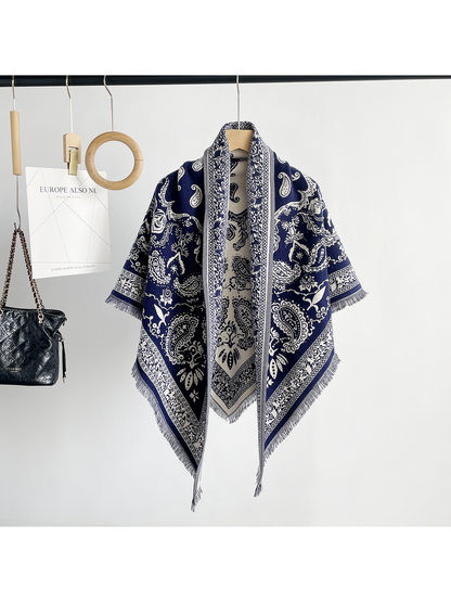 Gray paisley scarf draped on a hanger with contrasting ivory motifs and fringe