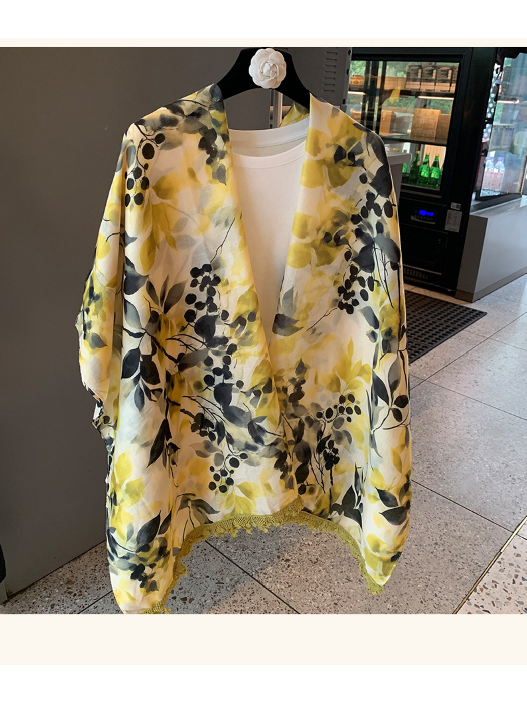 Multicolor botanical-print scarf hanging open, showing branching stems, berry-like clusters and yellow-green edge trim