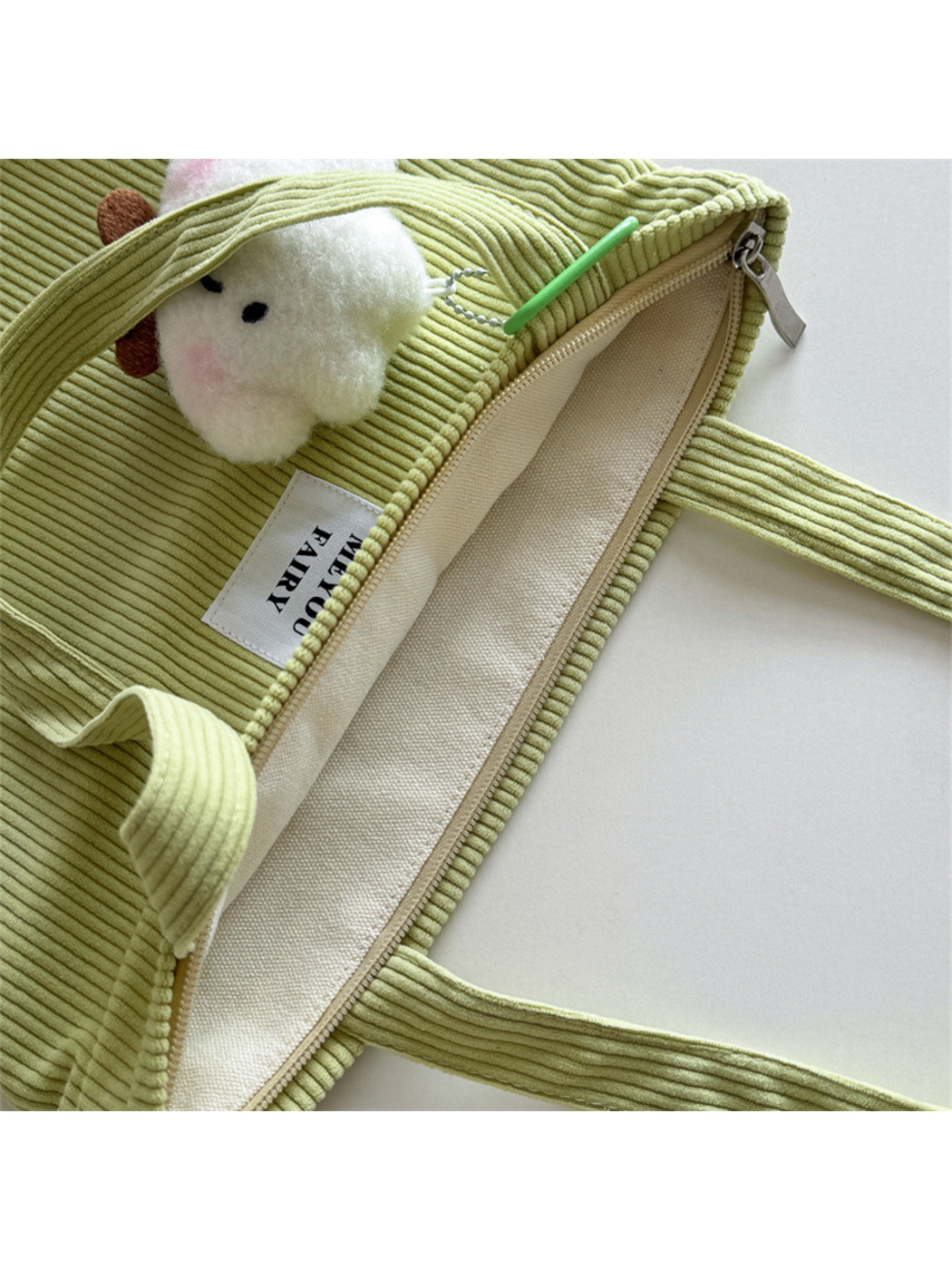 Close-up of Green tote bag opening and light beige interior