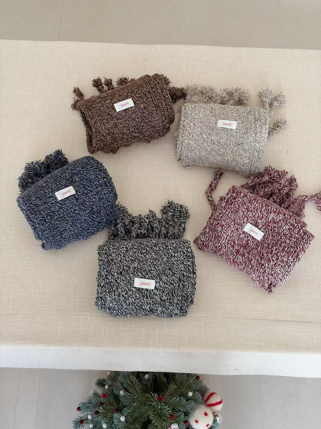 Brown, Gray, Navy, Black and Burgundy marled knit scarves folded into compact shapes