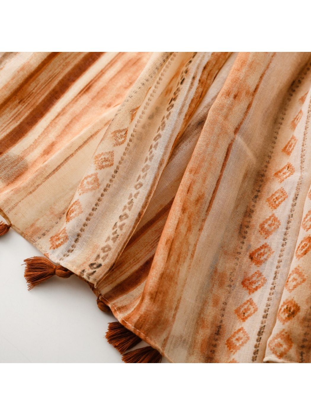 Close-up of striped scarf ends with diamond motifs and brown tassels
