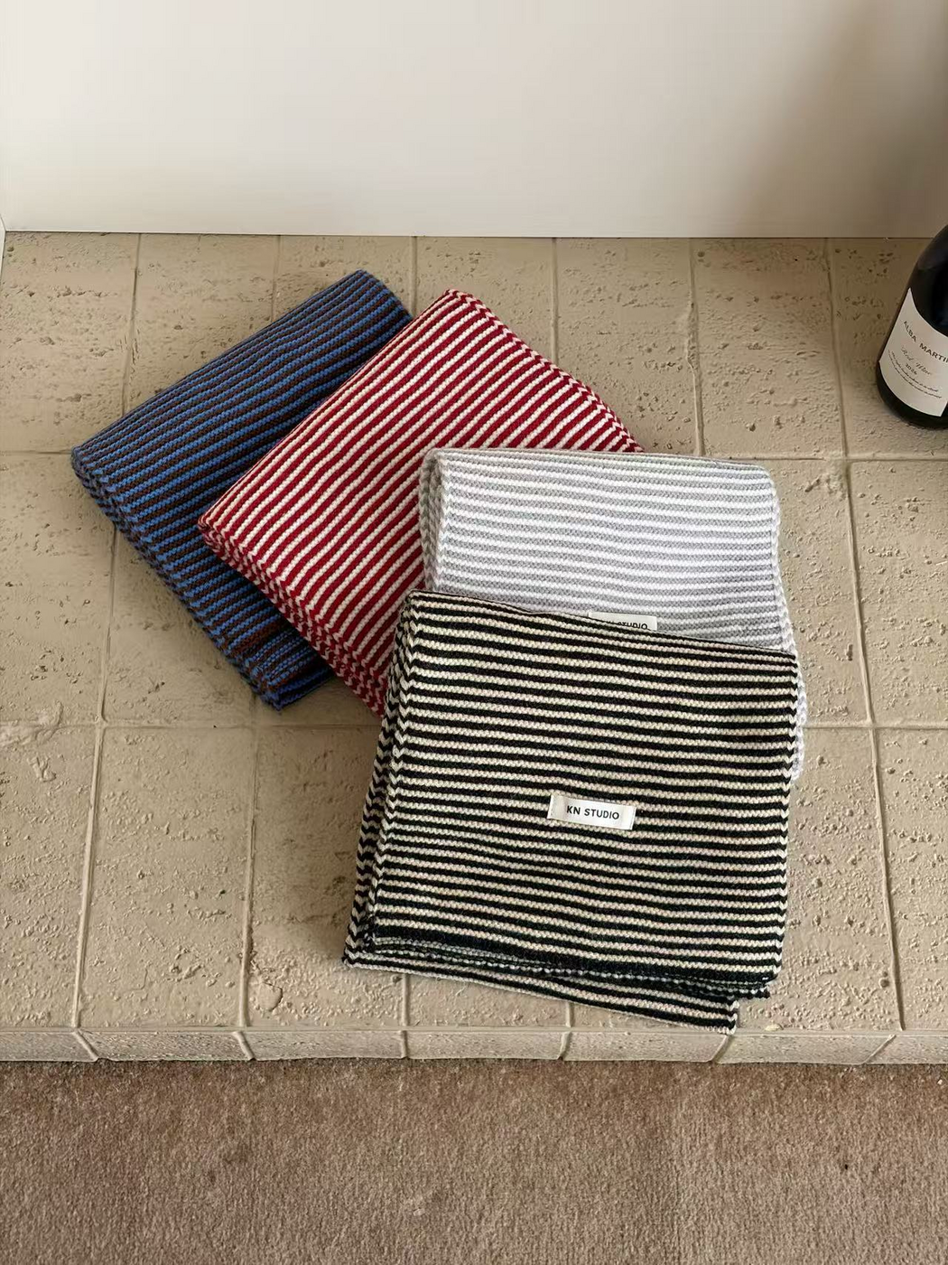Blue, Red, Gray and Black striped scarves arranged in overlapping folds