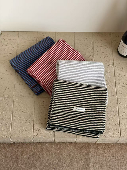 Blue, Red, Gray and Black striped scarves arranged in overlapping folds