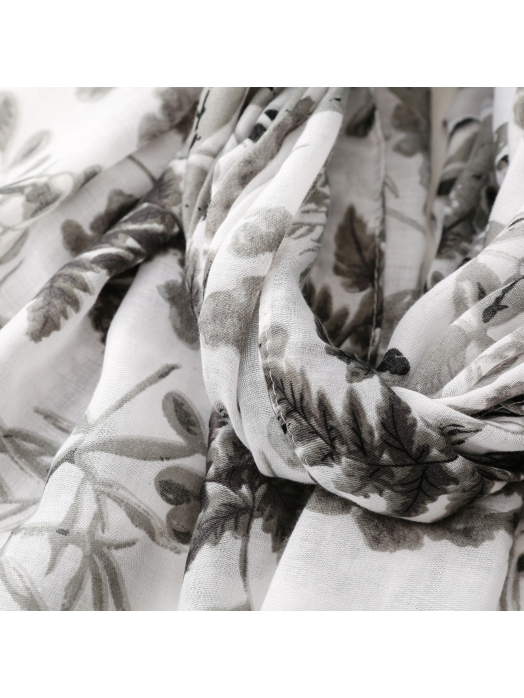 Close-up of Gray botanical scarf with dark fern motifs across looped folds