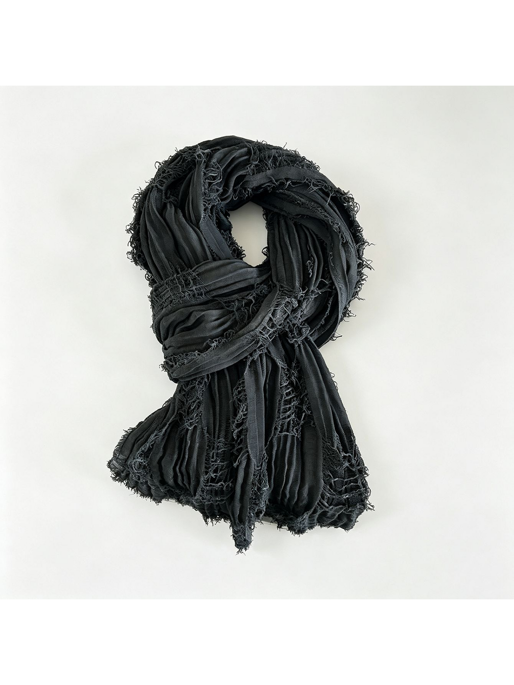 Dark textured scarf arranged in a loop, showing openwork strips and short fringed edges