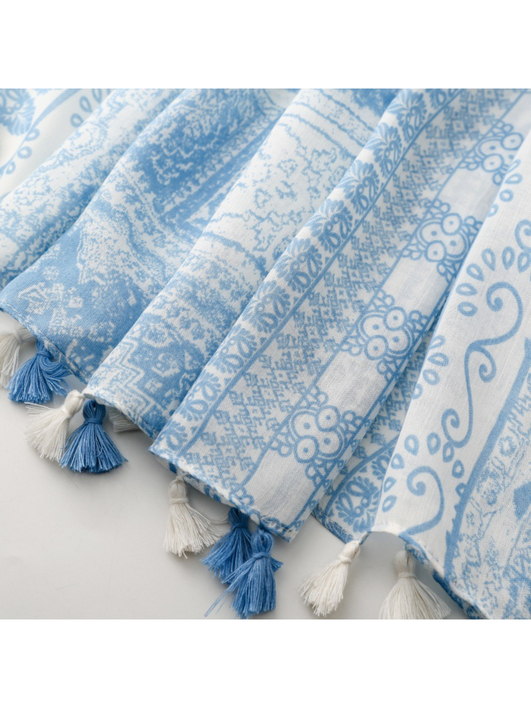 Close-up of blue and white tassels along the scarf's patterned edge