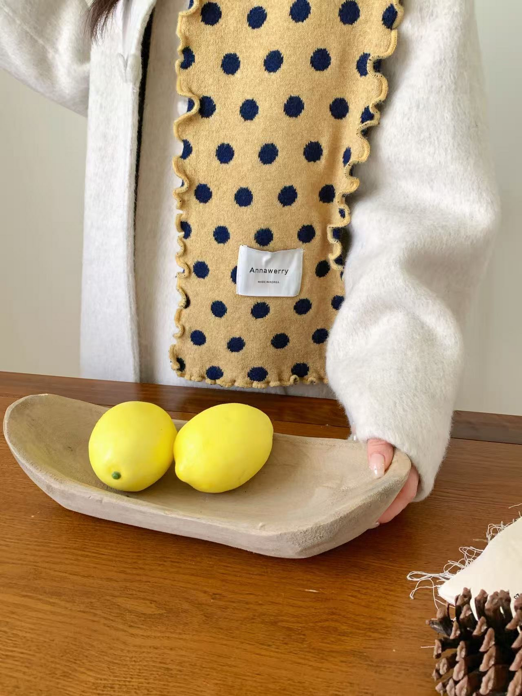 Close-up of the Yellow scarf showing navy polka dots, knit texture and ruffled edges