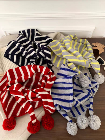Navy, Red, Blue and Yellow striped scarves displayed together with pom-pom details