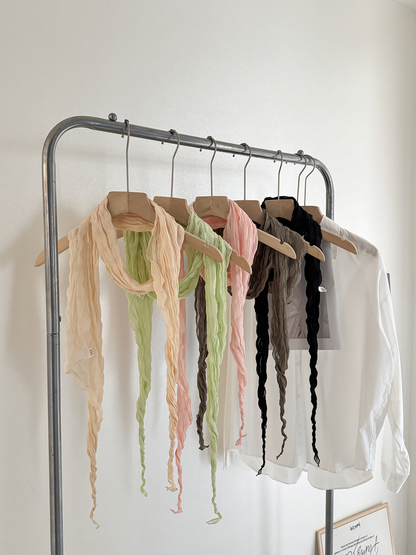 Beige, pale green, pink, greige and black crinkled scarves hanging together