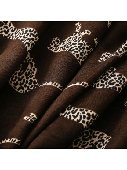 Close-up of spotted leopard silhouettes across brown scarf folds