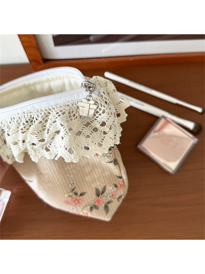 Beige floral pouch close-up showing scalloped ivory lace trim