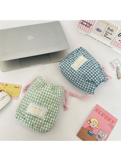 Green gingham pouch beside a sideways Teal Blue pouch showing its rounded base and gathered drawstring end