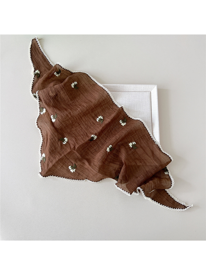 Brown triangle scarf draped open, showing floral embroidery and white openwork edging