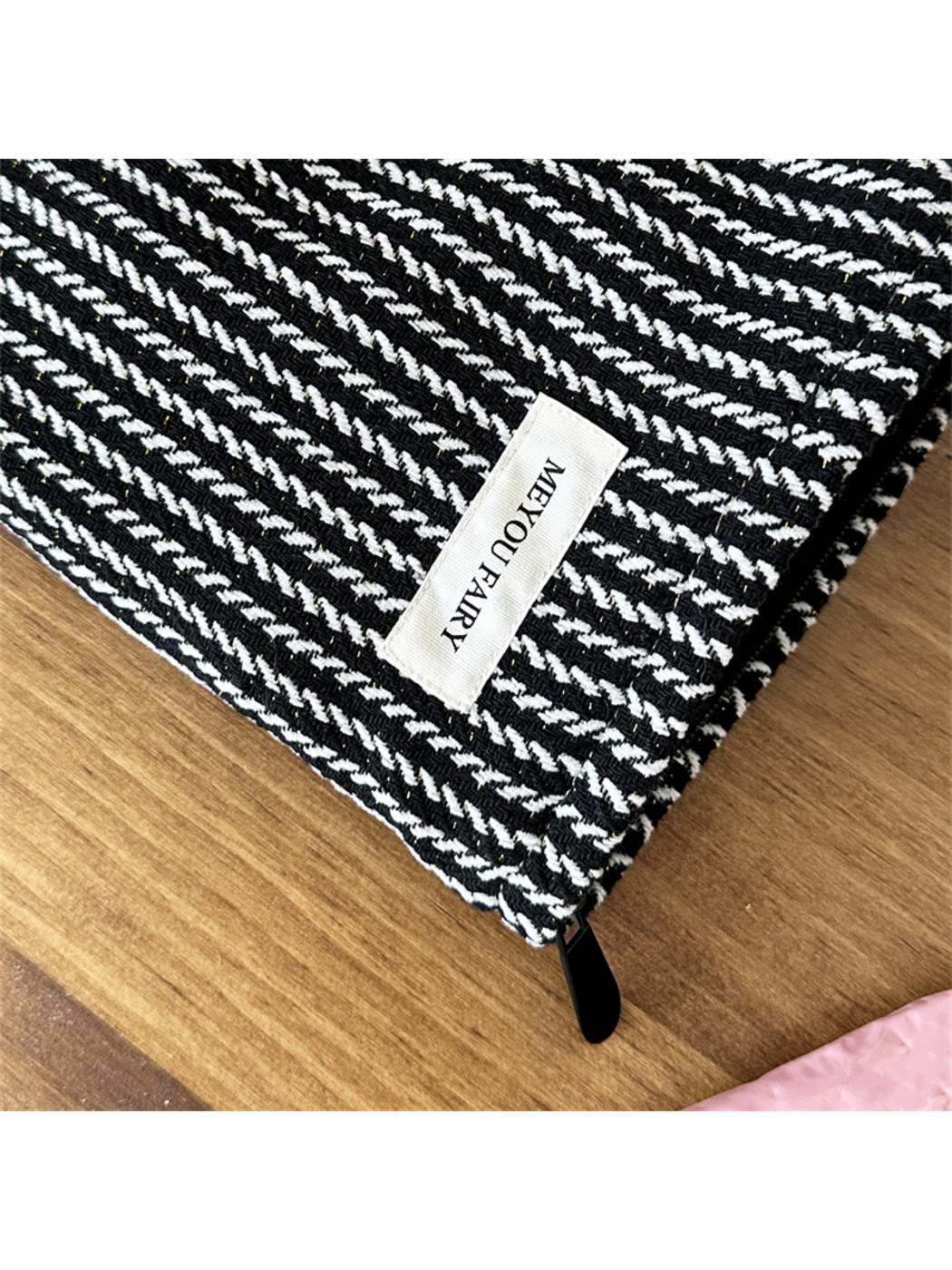 Close-up of the Black makeup pouch showing raised contrasting stitches and MEYOU FAIRY label