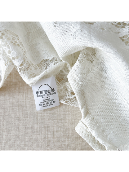 Close-up of White floral lace, fine textile texture and an attached cloth label