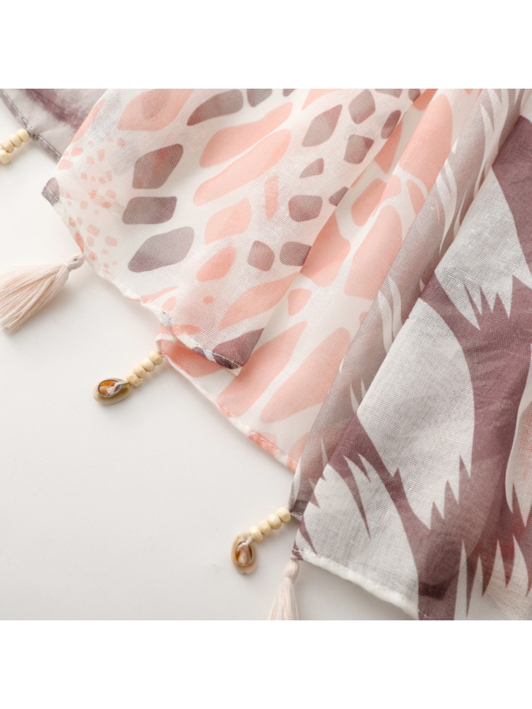 Close-up of the scarf edge with tassel trim beside spotted and jagged geometric panels