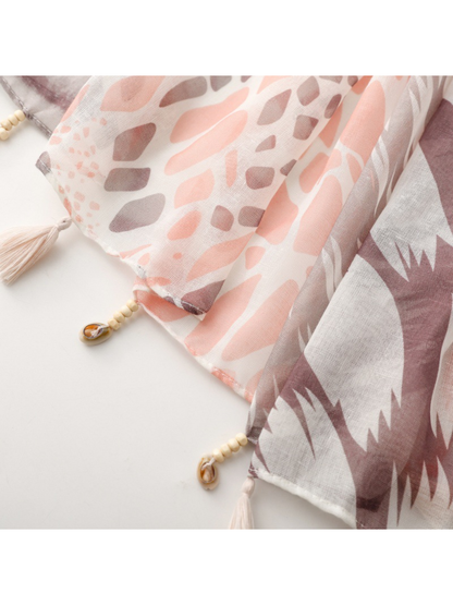 Close-up of the scarf edge with tassel trim beside spotted and jagged geometric panels