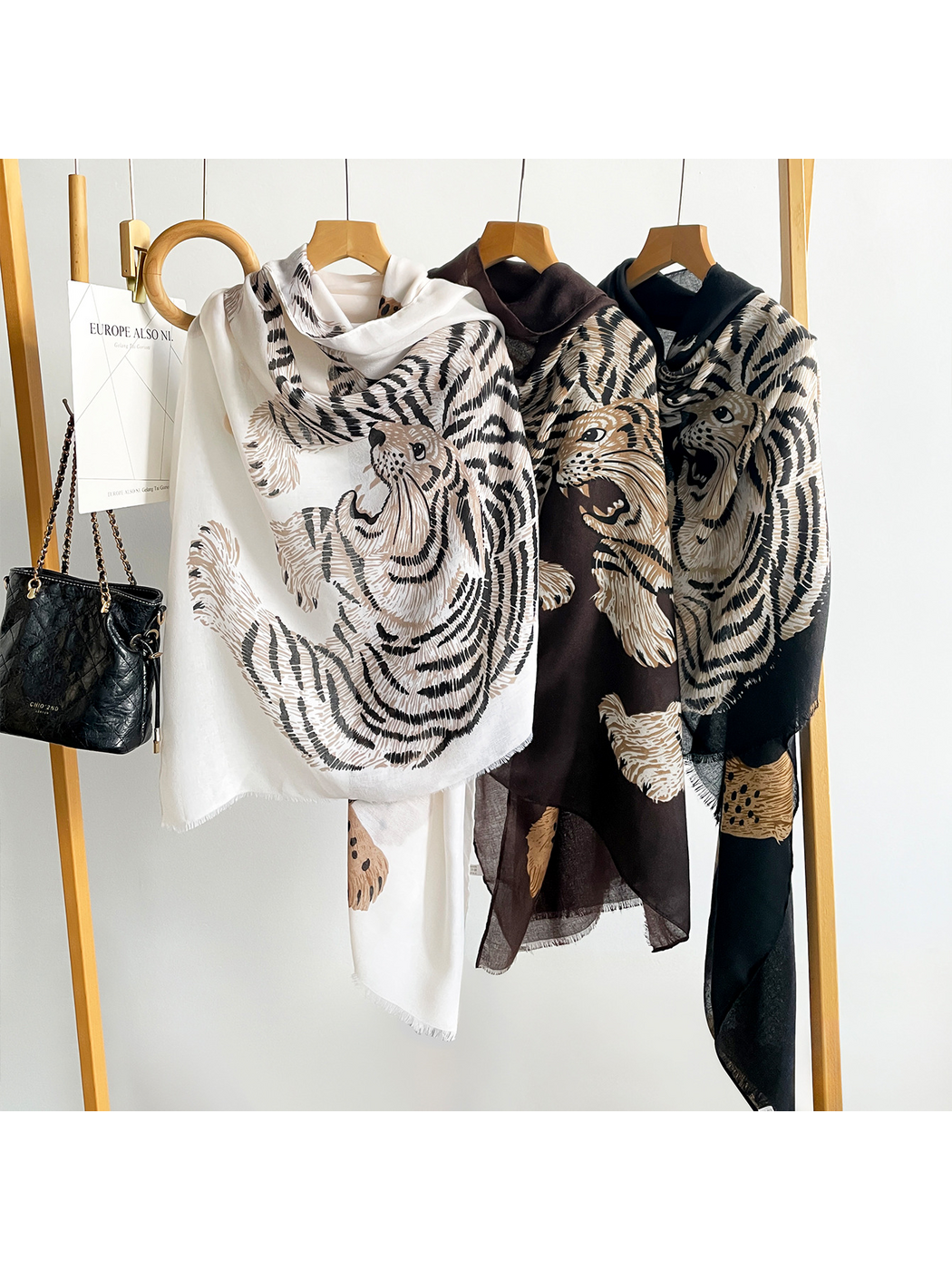 White, Brown and Black tiger-and-leopard scarves draped side by side on hangers