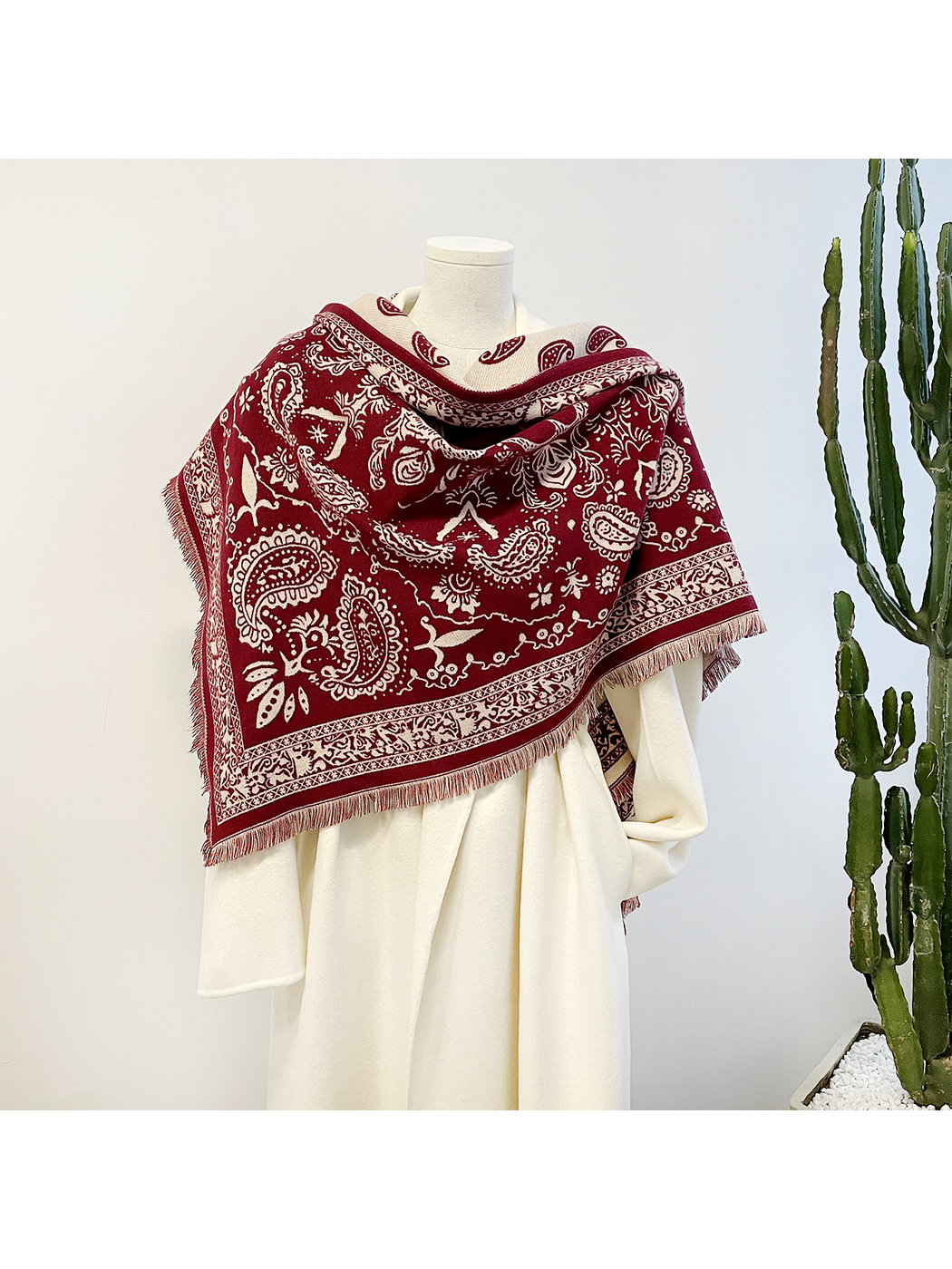 Red paisley scarf close-up showing ivory reverse, ornamental border and visible textile texture