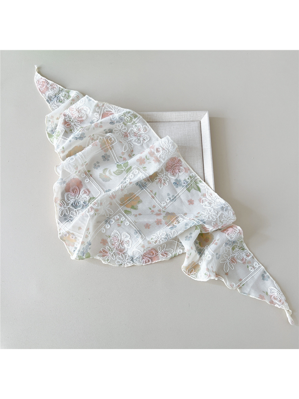 Floral scarf with white embroidery arranged in broad overlapping folds
