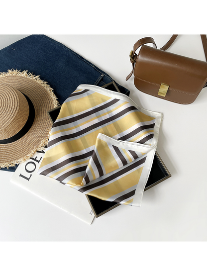 Yellow striped scarf loosely draped over a black tray