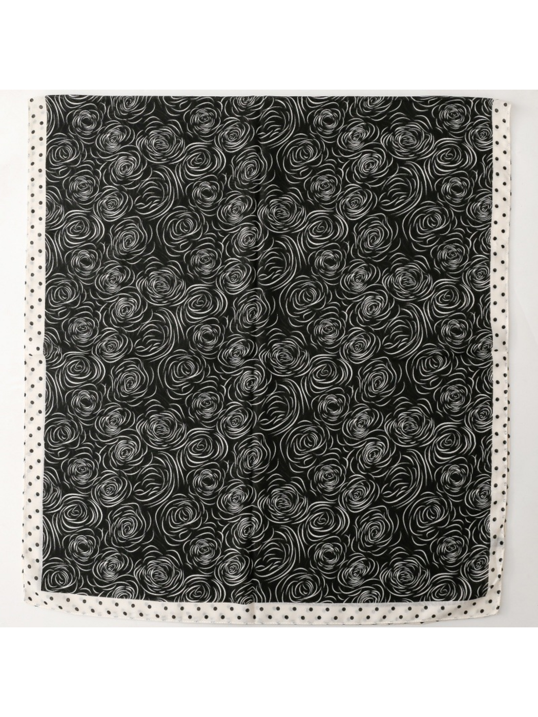 Scarf with white rose motifs on a dark ground, spread flat with a dotted border
