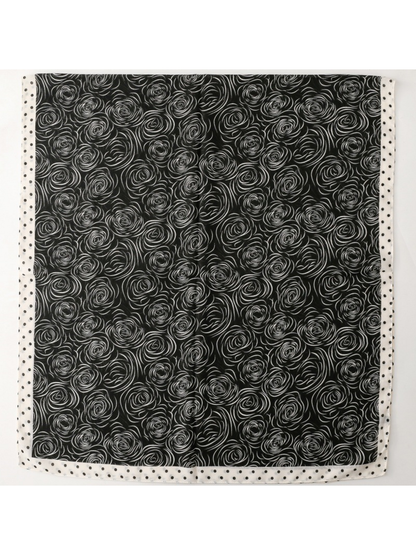 Scarf with white rose motifs on a dark ground, spread flat with a dotted border