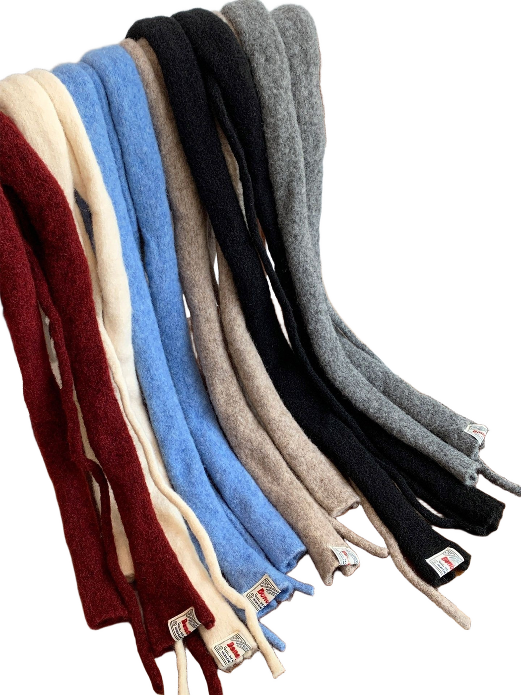 Several fuzzy narrow scarves draped over a wooden chair, showing long ends and attached labels